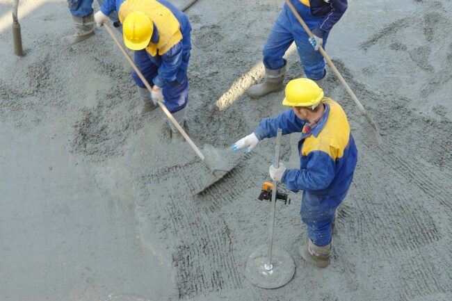 Workers spread wet cement