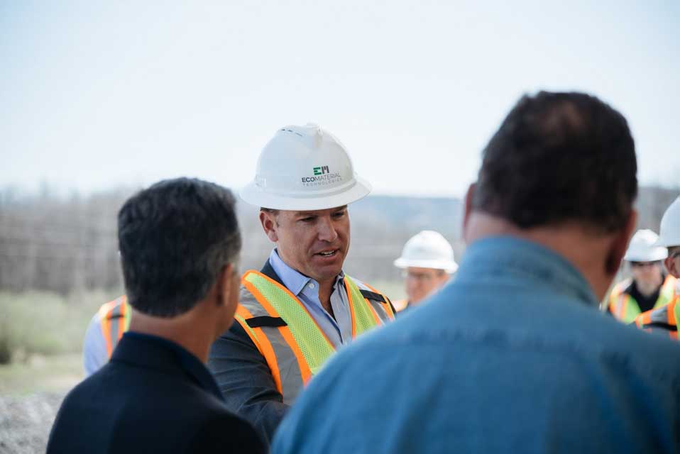 Grant Quasha in a hardhat speaking to others on a job site